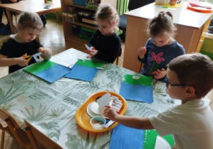 Zdjęcie przedstawia dzieci wykonujące pracę plastyczną.