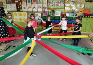 Zdjęcie przedstawia dzieci podczas zabawy z wiatrakiem matematycznym.