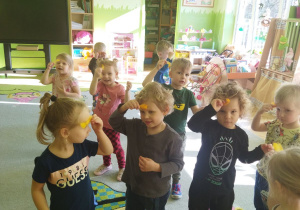 Na tym zdjęciu widać dziec z grupy I podczas wykonywania ćwiczenia oddechowego "Kolorwe piórka".