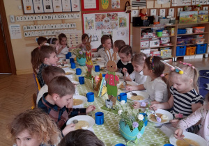 Zdjęcie przedstawia dzieci z grupy III przy wspólnym, światecznym stole.