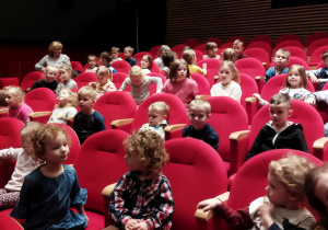 Zdjęcie przedstawia dzieci siedzące na widowni w teatrze.