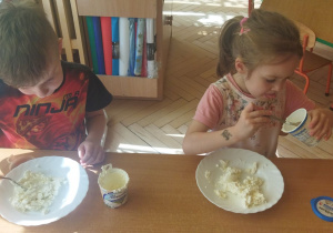 Na tym zdjęciu widać Piotrusia i Olę, którzy wykładają serek na talerze.