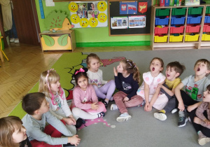 Zdjęcie przedstawia dzieci z grupy II wykonujące ćwiczenia narzadów mowy.