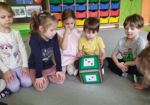Zdjęcie przedstawia dzieci z grupy II podczas zabaw logopedycznych z kostką.
