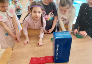 Na tym zdjęciu widać dziewczynki z grupy II układające woreczki zgodnie z poleceniem nauczycielki.