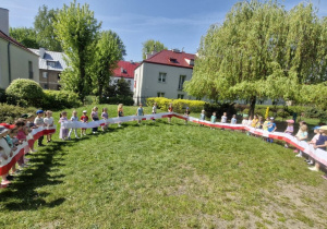 Na tym zdjęciu widać przedszkolaki prezentujące najdłuższą flagę Polski.