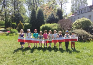 Zdjęcie przedstawia dzieci z grupy II prezentujące swoją flagę.