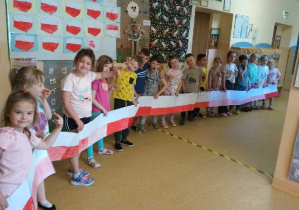 Zdjęcie przedstawia dzieci z grupy IV, które prezentują swoje flagi.