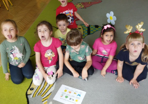 pZdjęcie przedstawia dzieci z grupy II podczas zabaw i ćwiczeń logopedycznych.