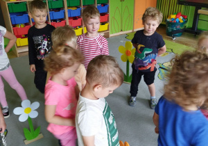Zdjęcie przedstawia dzieci z grupy I i III podczas zabawy "Na łace".