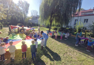 Zdjęcie przedstawia dzieci podczas zabaw z chustami animacyjnymi.