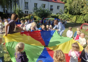 Zdjęcie przedstawia dzieci z grupy I podczasz zabawy z chustą aniamcyjną.