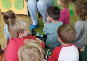 Na tym zdjęciu widać panią bibliotekarkę czytającą dzieciom bajkę.