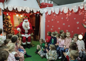 Zdjęcie przedstawia dzieci podczas spotkania z Mikołajem.