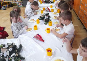 Na tym zdjęciu widać dzieci z grupy IV spożywające świąteczny obiad przy wspólnym stole.