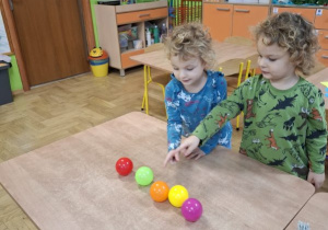 Na tym zdjęciu widać Oliwię i Mikołaja z grupy II przeliczajacych kolorowe piłeczki.