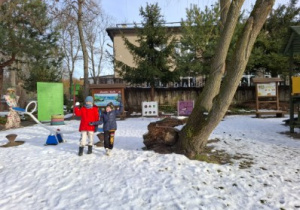 Na tym zdjęciu widać dwóch chłopców lepiących śnieżki.