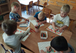 Na tym zdjęciu widać chłopców, którzy kolorują wzory na planszy według podanego rytmu.