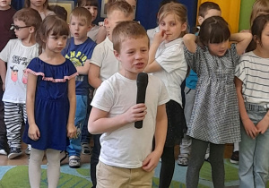 Zdjęcie przedstawia Maciusia z grupy IV recytującego wiersz.