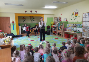 Zdjęcie przedstawia muzyków, wokalistę oraz dzieci.