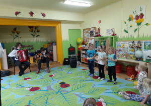 Na tym zdjęciu widać grającyh muzyków oraz Olka z grupy II i Wiktora oraz Oliwię z grupy IV grającyh na instrumentach perkusyjnych.