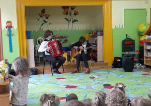 Zdjęcie przedstawia muzyków grających na akordeonie i gitarze.