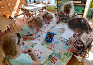 Zdjęcie przedstawia dzieci z grupy IV wykonujące ilustrację do wysłuchanego opowiadania.