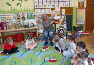 Zdjęcie przedstawia naszego gościa czytającego dzieciom bajkę.