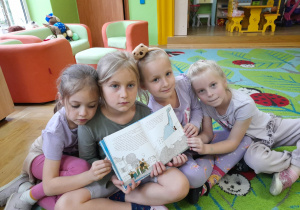 Zdjęcie przedstawia Helenkę, Celinkę, Tosię i Adelkę prezentujące jedną z ilustracji w czytanej książeczce.