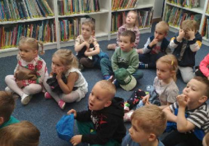 Na tym zdjęciu widać wszystkie dzieci słuchające opowieści pani bibliotekarki.