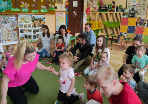 Zdjęcie przedstawia dzieci wraz z rodzicami podczas wspólnych zabaw.