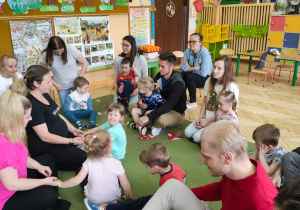 Zdjęcie przedstawia dzieci wraz z rodzicami podczas wspólnych zabaw.