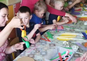 Zdjęcie przedstawia dzieci wraz z rodzicami podczas wykonywania pracy plastycznej.
