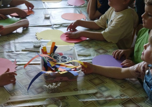 Zdjęcie przedstawia dzieci wraz z rodzicami podczas wykonywania pracy plastycznej.