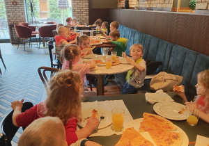 Zdjęcie przedstawia dzieci podczas wizyty w pizzeri.