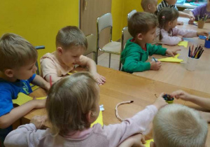 Zdjęcie przedstawia dzieci wykonujące pracę plastyczną.