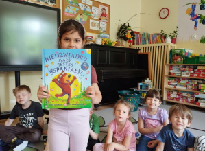 Głośne czytanie przez panią bibliotekarkę
