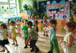 Zdjęcie przedstawia dzieci wykonujące układ taneczny.