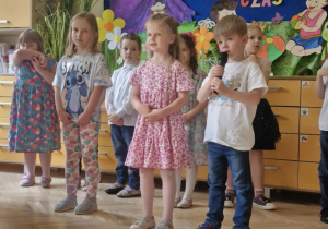 Zdjęcie przedstawia Klarę P., Alę R. i Filipa recytujących wierszyk.