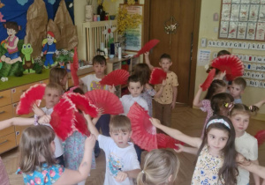 Zdjęcie przedstawia dzieci wykonujące taniec hiszpański z wachlarzami.
