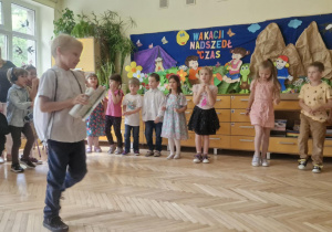 Zdjecie przedstawia dzieci śpiewające piosenkę z ilustracją ruchową.