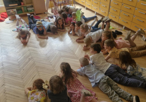 Zdjęcie przedstawia dzieci wykonujące układ taneczny.