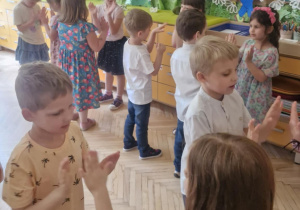 Zdjęcie przedstawia dzieci wykonujące układ taneczny.