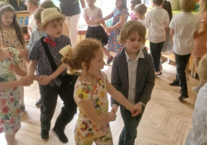 Zdjęcie przedstawia dzieci wykonujące układ taneczny.