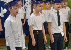 Zdjęcie przedstawia Stasia G., Anię i Kordiana recytujących wierszyk.
