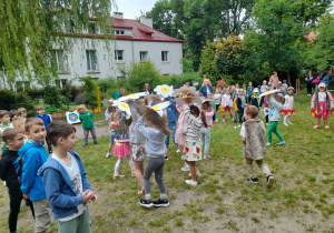 Zdjęcie przedstawia dzieci z grupy III i IV podczas prezentacji piosenki "Tango dla mamy i dla taty" z układem ruchowym.