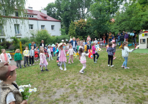 Zdjęcie przedstawia dzieci z grupy III i IV podczas prezentacji piosenki "Tango dla mamy i dla taty" z układem ruchowym.
