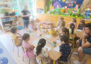 Na tym zdjęciu widać dzieci wykonujące kartę pracy, tatę Zuzi oraz nauczycielkę.