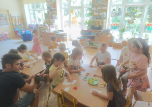 Na tym zdjęciu widać dzieci wykonujące pracę plastyczną oraz tatę Zuzi.