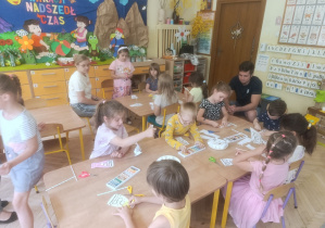 Na tym zdjęciu widać dzieci wykonujące pracę plastyczną oraz tatę Zuzi.